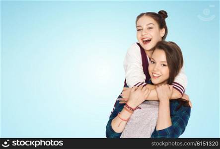 people, friends, teens and friendship concept - happy smiling pretty teenage girls hugging over blue background