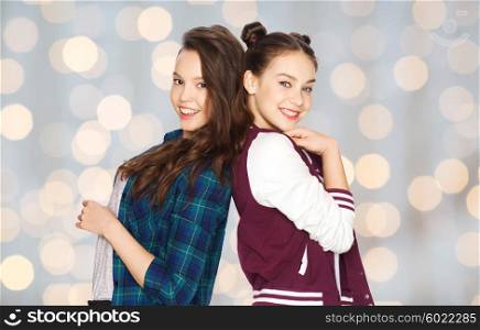 people, friends, teens and friendship concept - happy smiling pretty teenage girls over holidays lights background