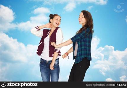 people, friends, teens and party concept - happy smiling pretty teenage girls dancing over blue sky and clouds background