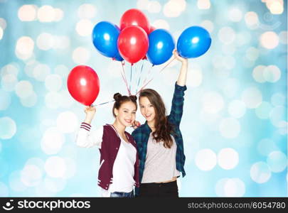 people, friends, teens, holidays and party concept - happy smiling pretty teenage girls with helium balloons over blue holidays lights background