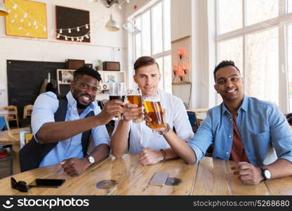 people, friendship and celebration concept - happy male friends drinking beer and clinking glasses at bar or pub. happy male friends drinking beer at bar or pub