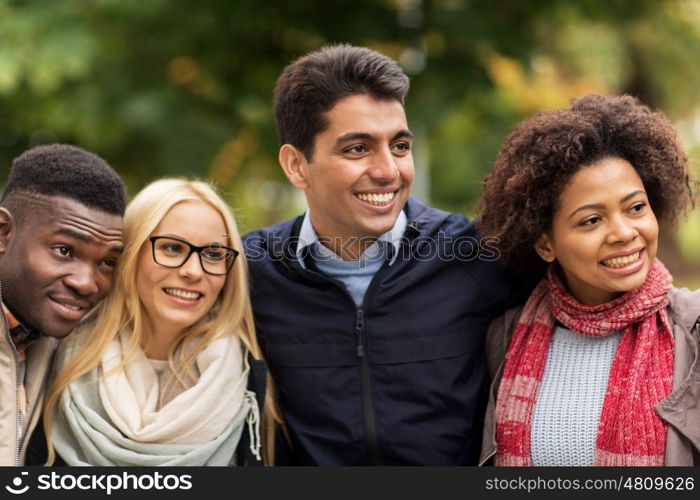 people, friendship and international concept - group of happy friends outdoors