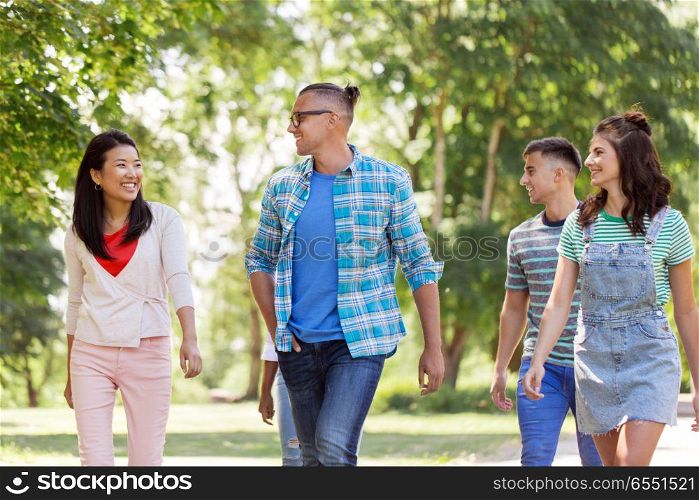 people, friendship and international concept - group of happy friends walking outdoors. group of happy international friends outdoors. group of happy international friends outdoors