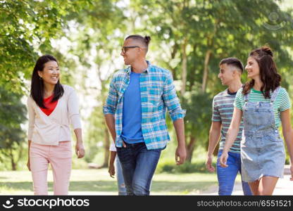 people, friendship and international concept - group of happy friends walking outdoors. group of happy international friends outdoors. group of happy international friends outdoors