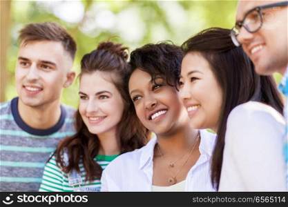 people, friendship and international concept - group of happy smiling friends outdoors. group of happy smiling friends outdoors