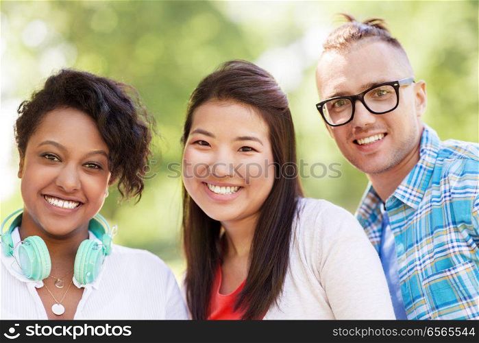 people, friendship and international concept - group of happy smiling friends outdoors. group of happy smiling friends outdoors