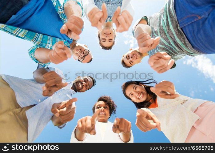 people, friendship and international concept - group of happy smiling friends outdoors standing in circle and pointing at you. happy friends pointing at you standing in circle