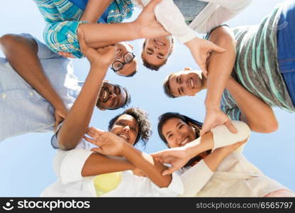 people, friendship and international concept - group of happy smiling friends outdoors standing in circle. happy smiling friends outdoors standing in circle