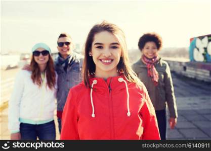 people, friendship and international concept - happy young woman or teenage girl in front of her friends on city street
