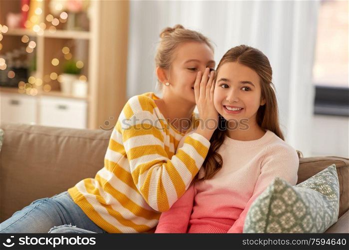 people, friendship and secret concept - happy teenage girls gossiping at home. happy teenage girls gossiping at home