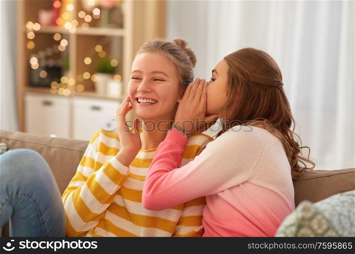 people, friendship and secret concept - happy teenage girls gossiping at home. happy teenage girls gossiping at home