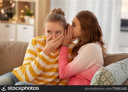 people, friendship and secret concept - teenage girls gossiping at home. teenage girls gossiping at home
