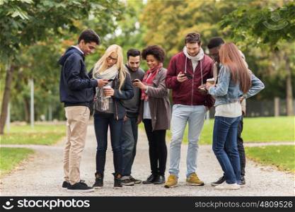 people, friendship, communication, technology and international concept - group of happy friends with smartphone and coffee outdoors