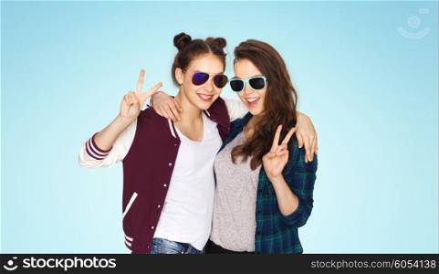 people, friendship, fashion, summer and teens concept - happy smiling pretty teenage girls in sunglasses showing peace hand sign over blue background