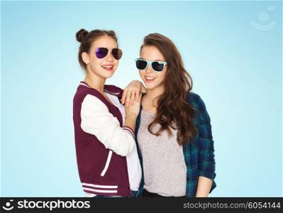 people, friendship, fashion, summer and teens concept - happy smiling pretty teenage girls in sunglasses over blue background