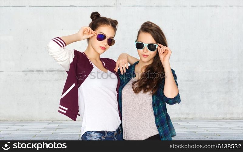 people, friendship, fashion, summer and teens concept - happy smiling pretty teenage girls in sunglasses over urban street background