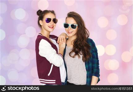people, friendship, fashion, summer and teens concept - happy smiling pretty teenage girls in sunglasses over pink holidays lights background