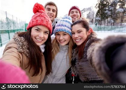 people, friendship, technology, winter and leisure concept - happy friends taking selfie with smartphone or camera outdoors