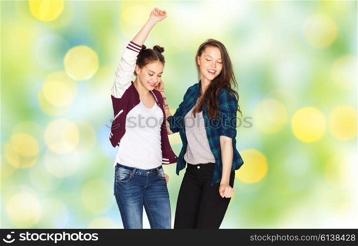 people, fun, teens and party concept - happy smiling pretty teenage girls dancing over green summer holidays lights background