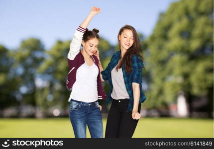 people, fun, teens and party concept - happy smiling pretty teenage girls dancing over summer park background