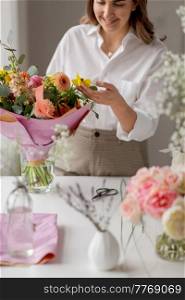 people, gardening and floral design concept - happy smiling woman or floral artist with bunch of flowers working at studio. happy woman or floral artist with flowers at home