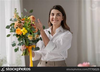 people, gardening and floral design concept - happy smiling woman or floral artist with bunch of flowers at home. happy woman with bunch of flowers at home