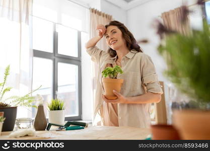 people, gardening and housework concept - tired smiling woman planting pot flowers at home. tired woman planting pot flowers at home