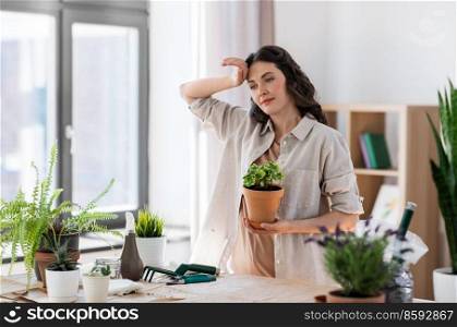 people, gardening and housework concept - tired woman planting pot flowers at home. tired woman planting pot flowers at home