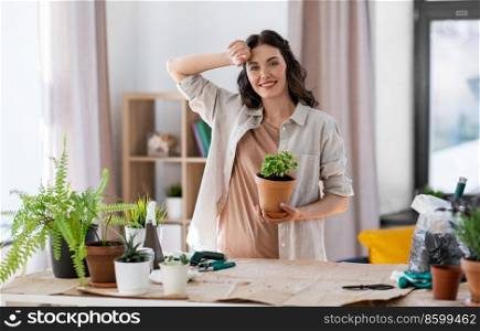 people, gardening and housework concept - tired woman planting pot flowers at home. tired woman planting pot flowers at home