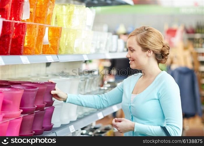 people, gardening, shopping, sale and consumerism concept - happy woman choosing flower pot in shop