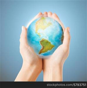 people, geography, population and peace concept - close up of human hands with earth globe showing american continent over blue background