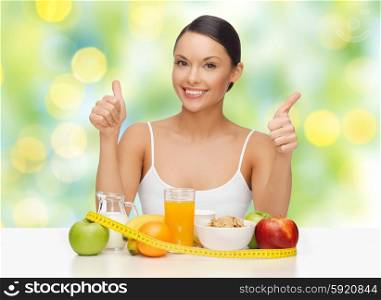 people, gesture and diet concept- happy asian woman with healthy food showing thumbs up over green lights background