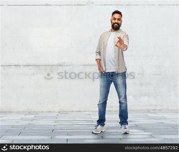 people, gesture and ethnicity concept - happy smiling indian man showing ok hand sign over stone wall background