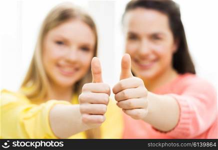 people, gesture and friendship concept - close up of happy teenage girls showing thumbs up