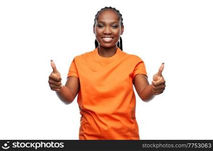 people, gesture and portrait concept - happy young woman showing thumbs up over white background. happy woman showing thumbs up