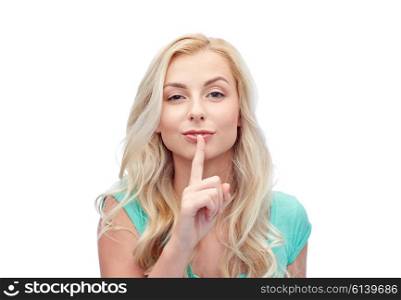 people, gesture and secret concept - beautiful young woman holding finger at her lips