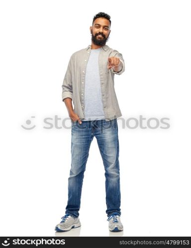 people, gesture, choice and ethnicity concept - happy smiling indian man pointing finger to you over white. happy smiling indian man pointing finger to you