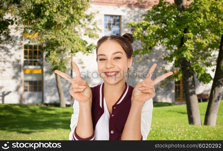 people, gesture, school, education and teens concept - happy smiling student teenage girl showing peace sign over summer campus background