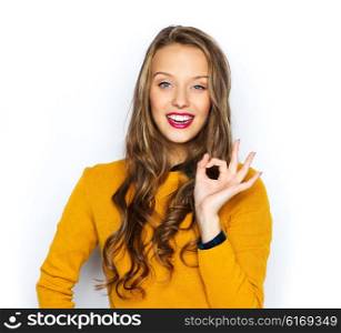 people, gesture, style and fashion concept - happy young woman or teen girl in casual clothes showing ok hand sign