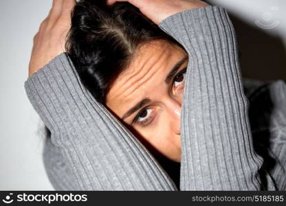 people, grief and domestic violence concept - close up of unhappy woman sitting on floor and crying. close up of unhappy woman crying on floor