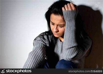 people, grief and domestic violence concept - unhappy woman sitting on floor and crying. unhappy woman crying on floor