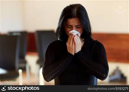 people, grief and mourning concept - crying woman with wipe at funeral in church. crying woman with wipe at funeral in church