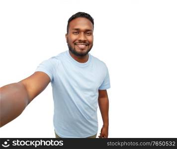 people, grooming and beauty concept - portrait of happy smiling young african american man taking selfie over white background. smiling young african american man taking selfie