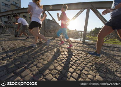 people group jogging runners team on morning training workout with sunrise in background