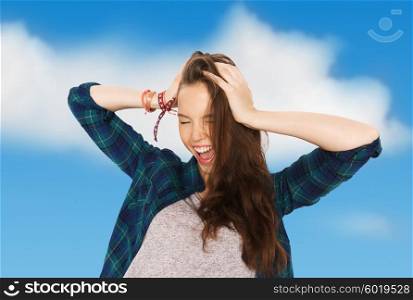 people, hair care, style and teens concept - happy pretty teenage girl holding to head over blue sky and clouds background