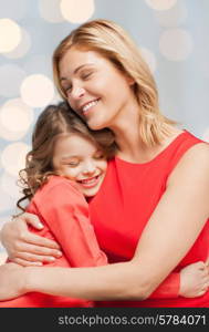 people, happiness, love, family and motherhood concept - happy mother and daughter hugging over holiday lights background