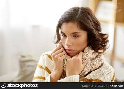 people, health and cold concept - sad sick woman in scarf at home. sad sick woman in scarf at home