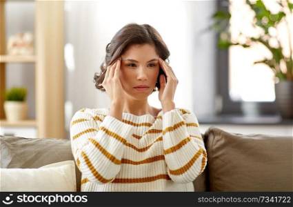 people , health and stress concept - unhappy woman suffering from head ache at home. unhappy woman suffering from head ache at home
