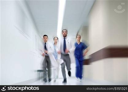people, health care and medicine concept - group of medics running along hospital (motion blur effect). group of medics walking along hospital