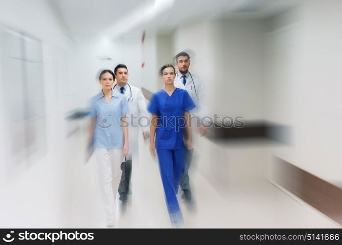 people, health care and medicine concept - group of medics walking along hospital (motion blur effect). group of medics or doctors walking along hospital